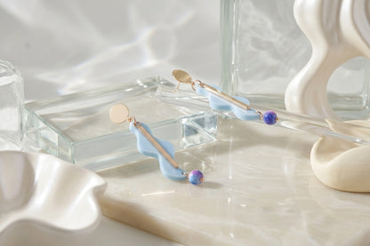 Blue Esme long acrylic statement earrings in a styled product setting