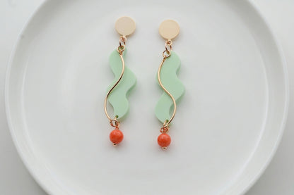 Green Esme long acrylic statement earrings arranged on a white plate