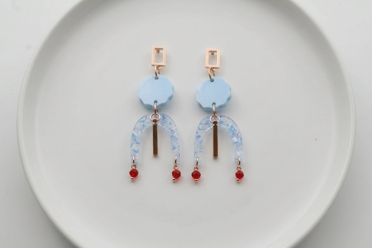 Blue Eva geometric beaded drop earrings arranged on a white plate
