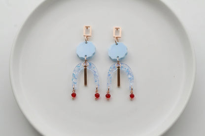 Blue Eva geometric beaded drop earrings arranged on a white plate