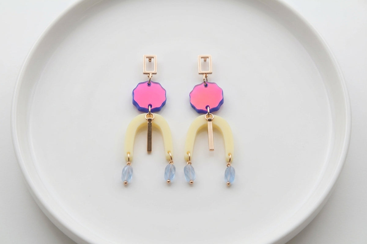 HB Eva geometric beaded drop earrings arranged on a white plate
