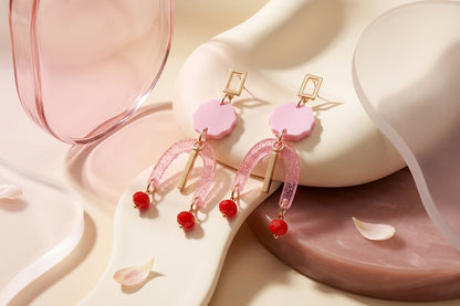 Pink Eva geometric beaded drop earrings in a styled product setting