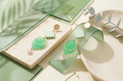 Green Fien long geometric drop earrings in a styled product setting
