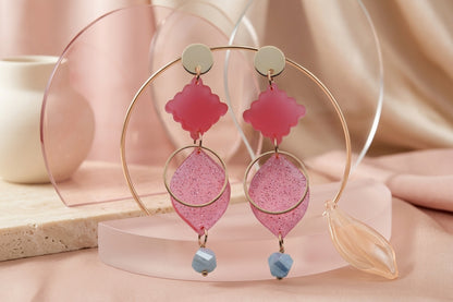 Pink Fien long geometric drop earrings in a styled product setting