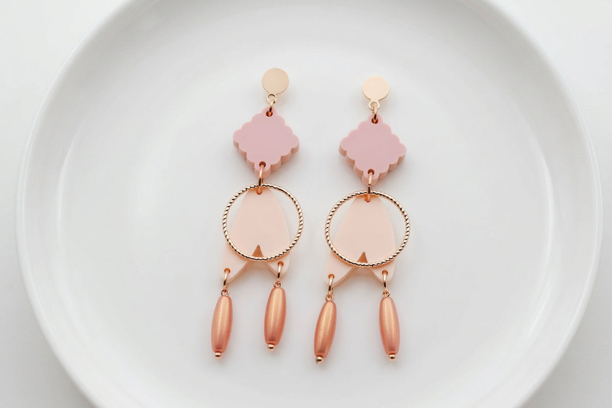 Beige Fleur geometric acrylic statement earrings arranged on a white plate