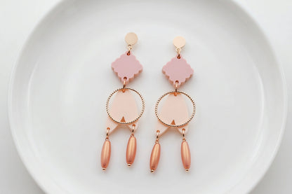 Beige Fleur geometric acrylic statement earrings arranged on a white plate