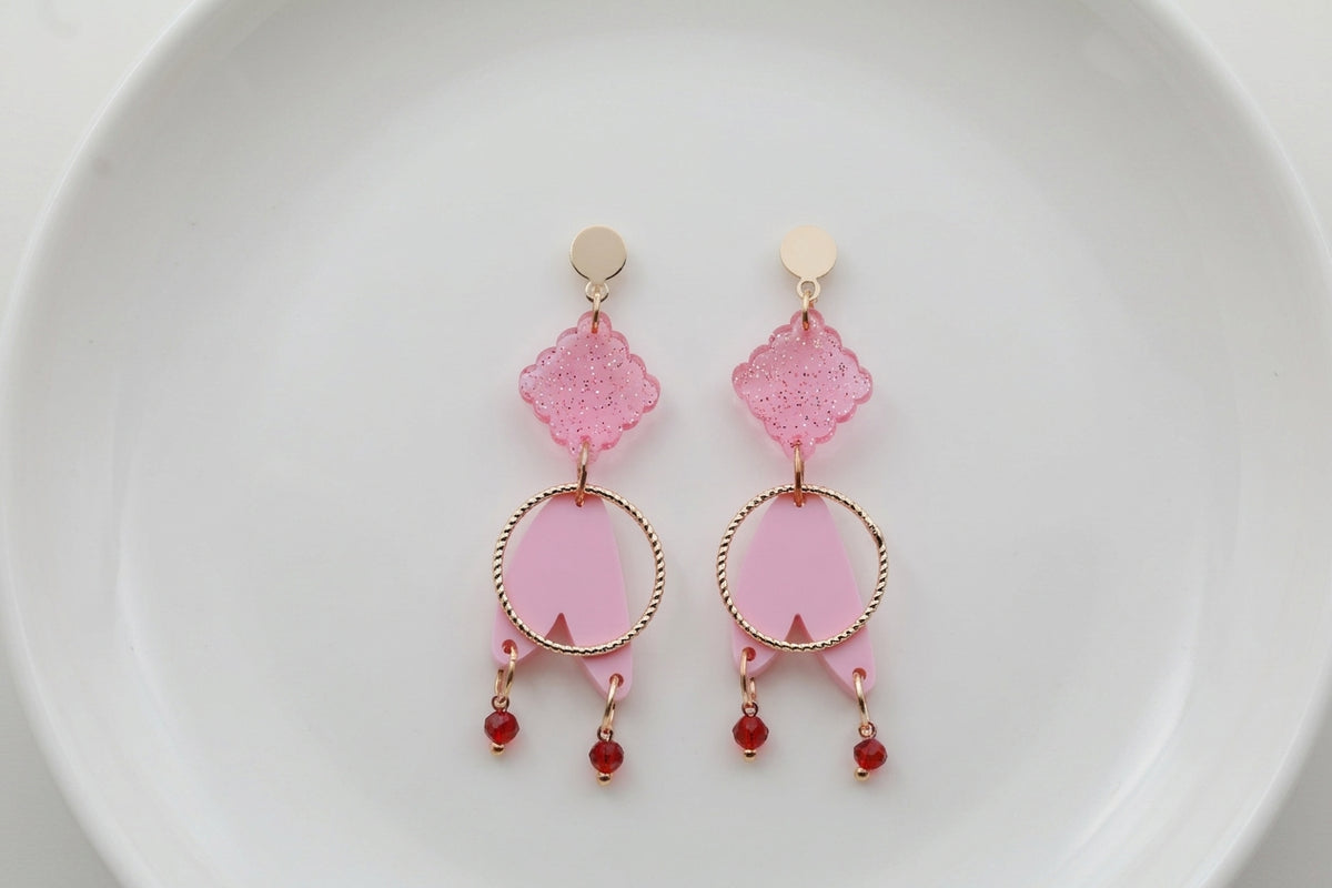 Pink Fleur geometric acrylic statement earrings arranged on a white plate