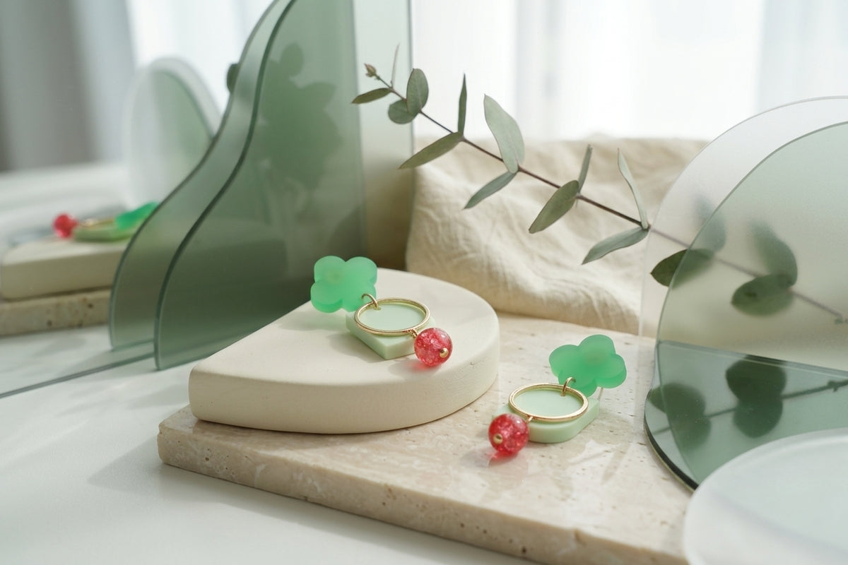 Green Freya small geometric dangle earrings in a styled product setting