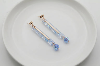 Blue Ina long rectangle acrylic earrings arranged on a white plate