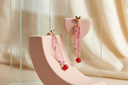 Pink Ina long rectangle acrylic earrings in a styled product setting