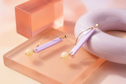 Purple Ina long rectangle acrylic earrings in a styled product setting