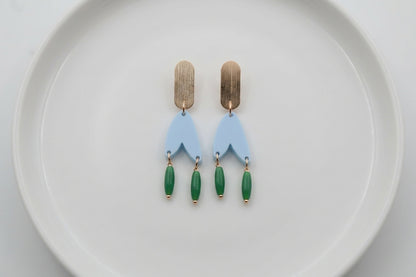 Blue Iris geometric long drop earrings arranged on a white plate