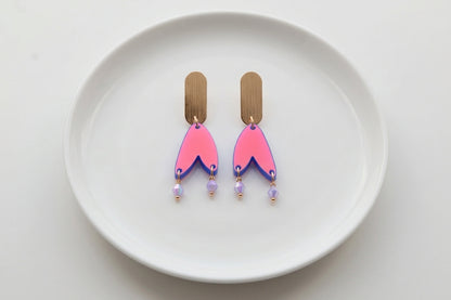 HB Iris geometric long drop earrings arranged on a white plate
