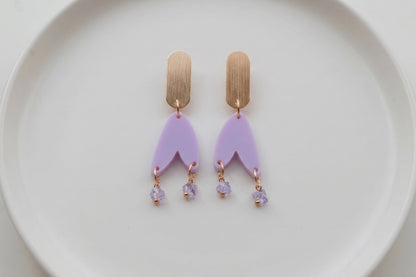 Purple Iris geometric long drop earrings arranged on a white plate