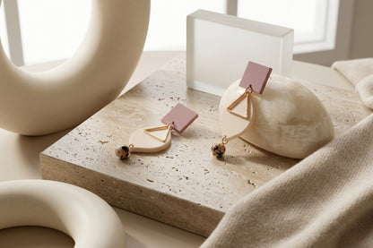 Beige Lara heart acrylic dangle earrings in a styled product setting