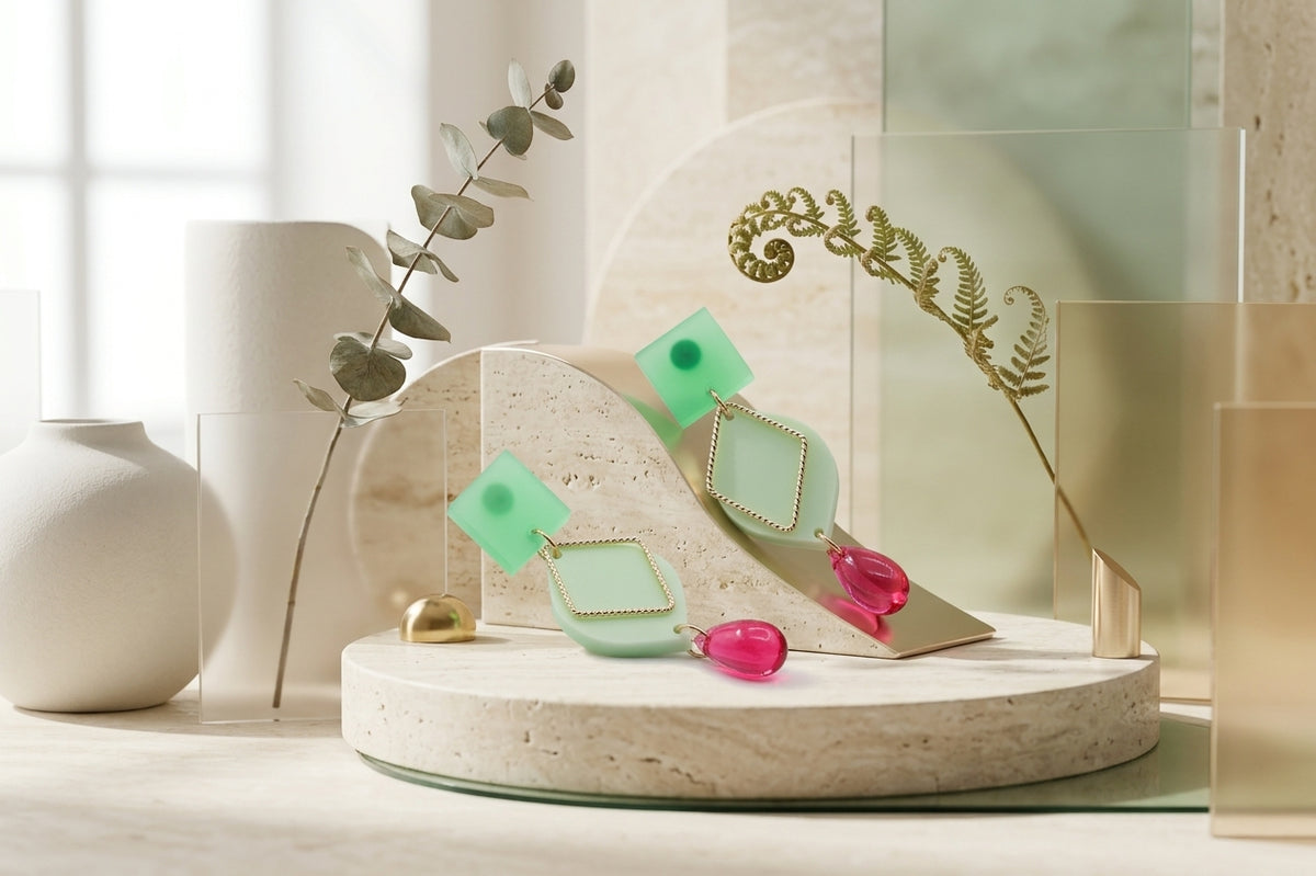 Green Lara heart acrylic dangle earrings in a styled product setting