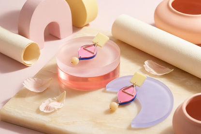 HB Lara heart acrylic dangle earrings in a styled product setting