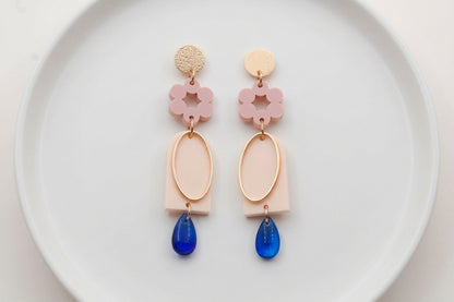 Beige Lena floral long drop earrings arranged on a white plate