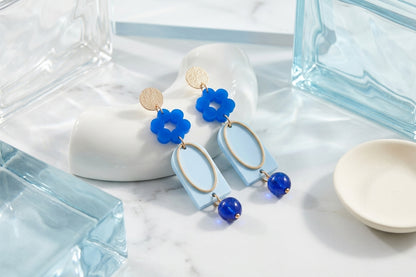 Blue Lena floral long drop earrings in a styled product setting