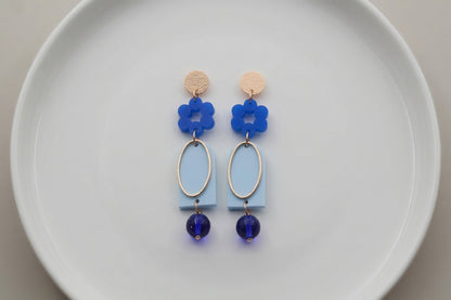 Blue Lena floral long drop earrings arranged on a white plate