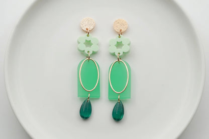 Green Lena floral long drop earrings arranged on a white plate
