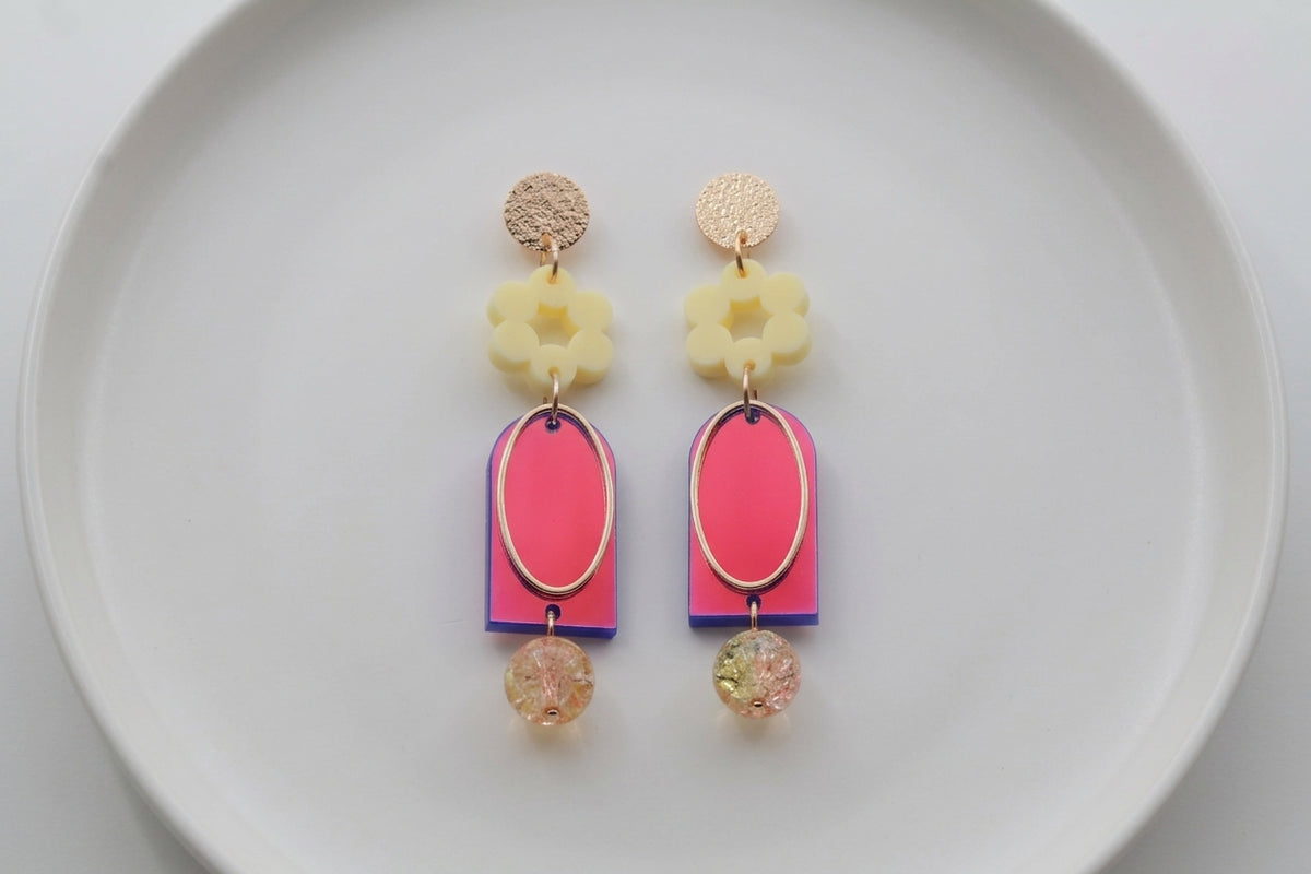 HB Lena floral long drop earrings arranged on a white plate