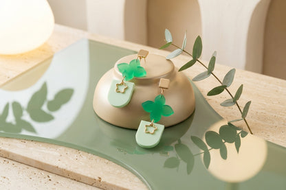 Green Lia floral heart drop earrings in a styled product setting