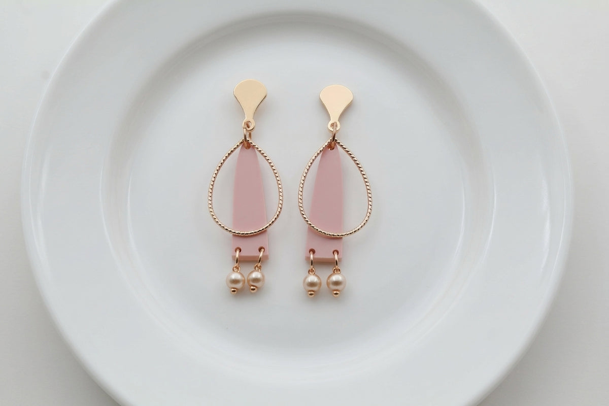 Beige Lina long geometric acrylic earrings arranged on a white plate