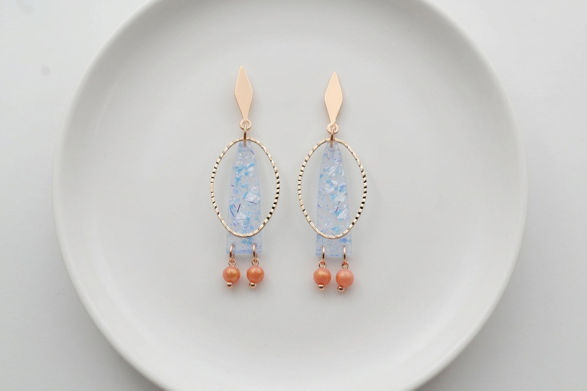 Blue Lina long geometric acrylic earrings arranged on a white plate