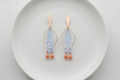 Blue Lina long geometric acrylic earrings arranged on a white plate