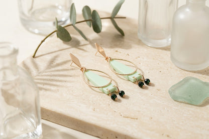 Green Lina long geometric acrylic earrings in a styled product setting
