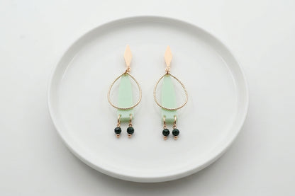 Green Lina long geometric acrylic earrings arranged on a white plate
