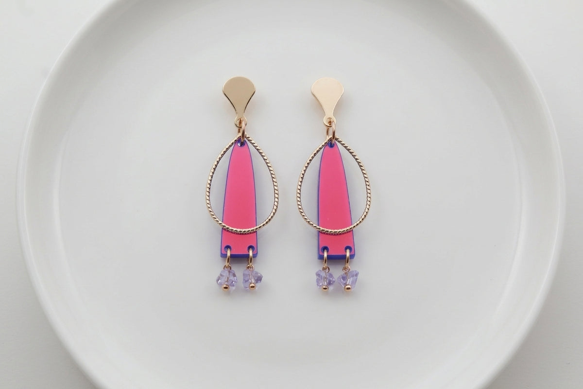 HB Lina long geometric acrylic earrings arranged on a white plate