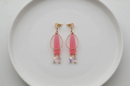 Pink Lina long geometric acrylic earrings arranged on a white plate