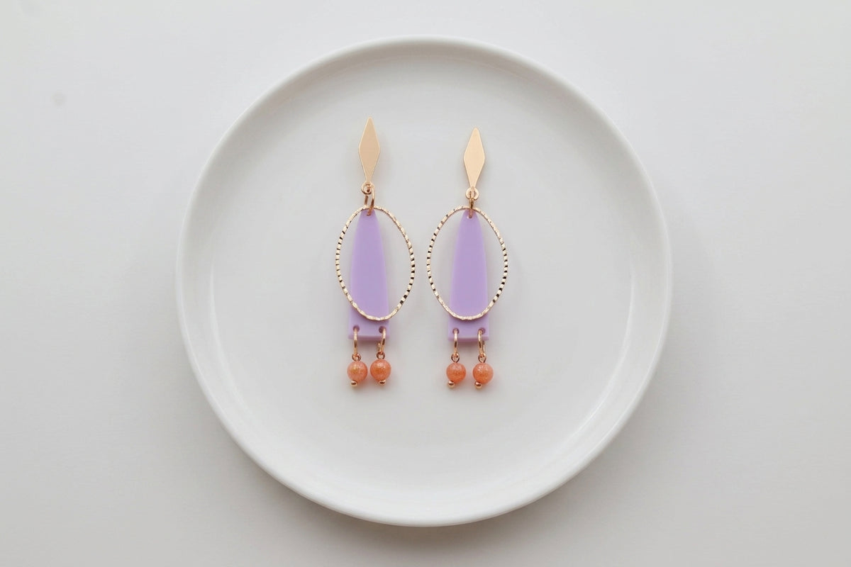 Purple Lina long geometric acrylic earrings arranged on a white plate