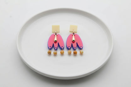 HB Liv acrylic beaded statement earrings arranged on a white plate