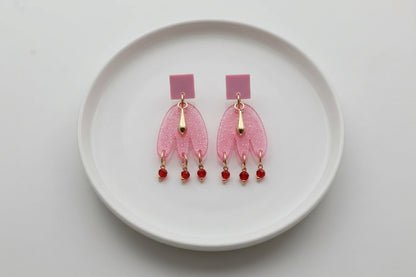 Pink Liv acrylic beaded statement earrings arranged on a white plate
