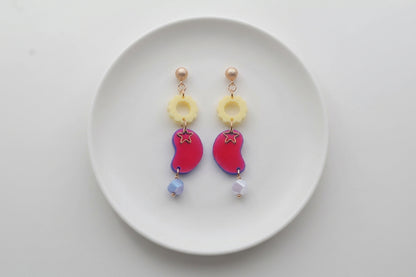 HB Lucia floral star dangle earrings arranged on a white plate