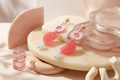 Pink Lucia floral star dangle earrings in a styled product setting