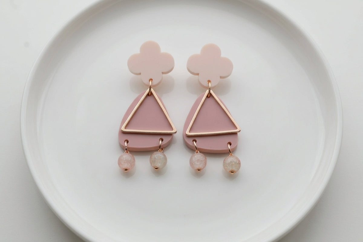 Beige Maud flower statement earrings arranged on a white plate