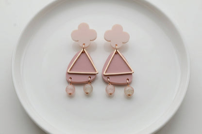 Beige Maud flower statement earrings arranged on a white plate