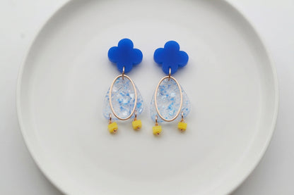 Blue Maud flower statement earrings arranged on a white plate