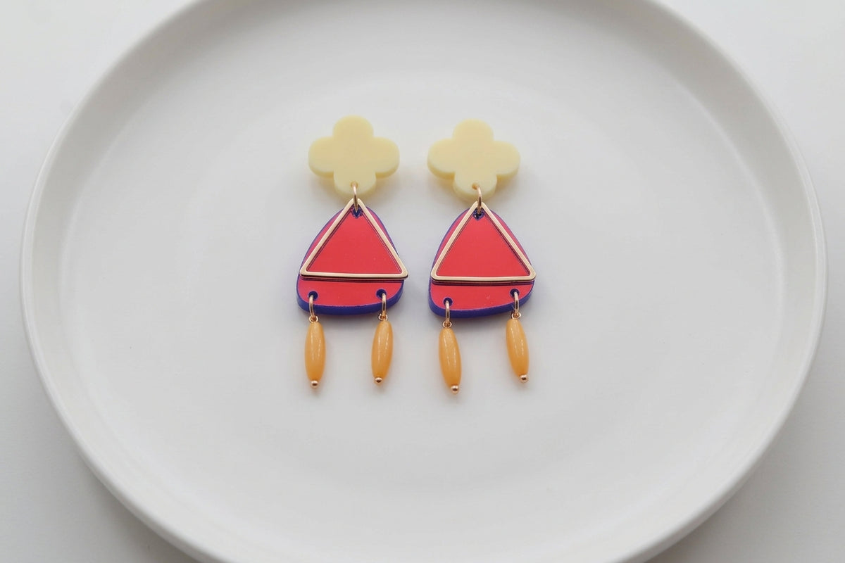 HB Maud flower statement earrings arranged on a white plate