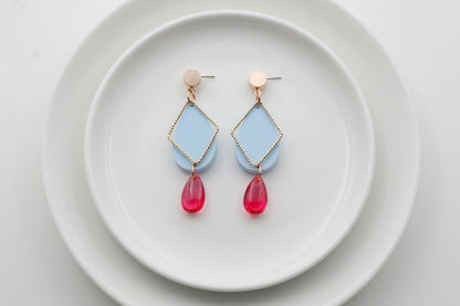 Blue Mia geometric teardrop earrings arranged on a white plate