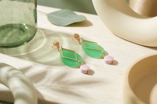 Green Mia geometric teardrop earrings in a styled product setting
