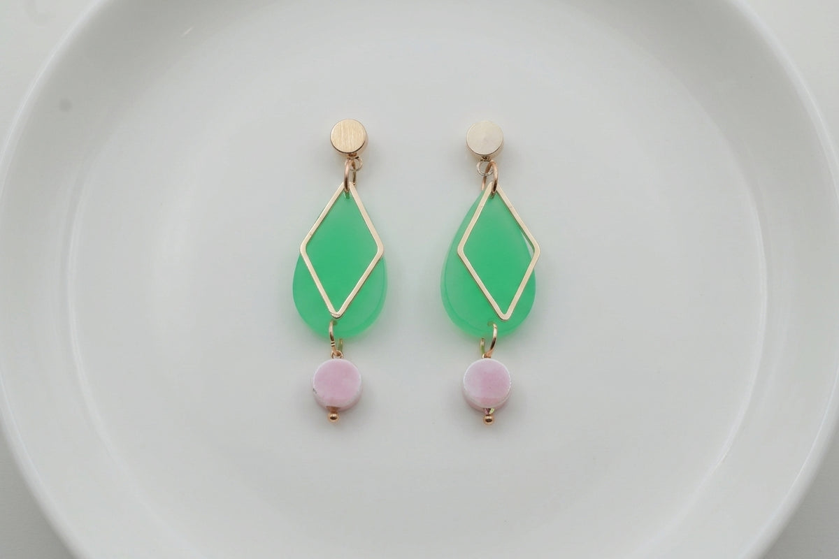 Green Mia geometric teardrop earrings arranged on a white plate