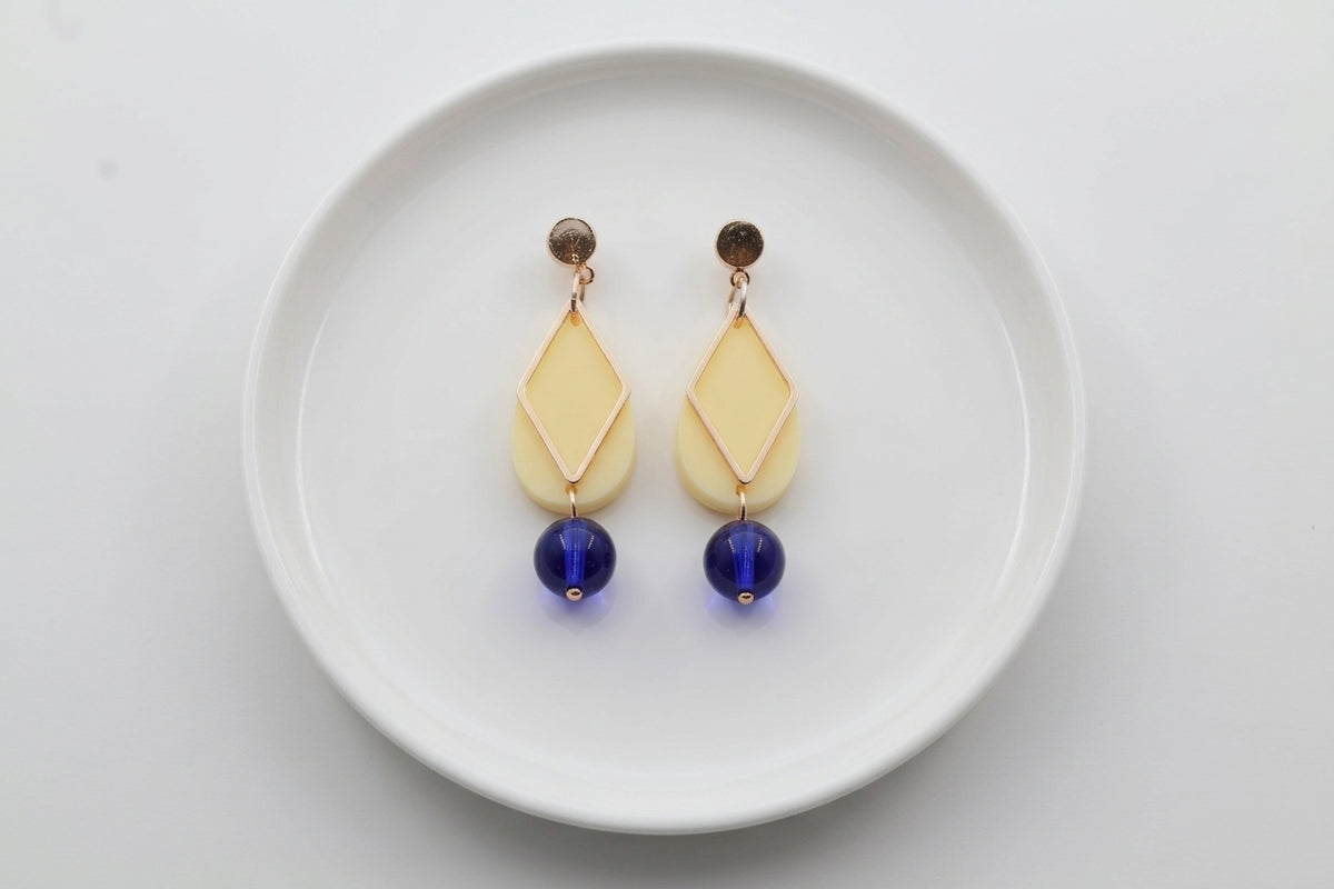 HB Mia geometric teardrop earrings arranged on a white plate
