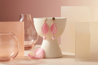 Pink Mia geometric teardrop earrings in a styled product setting