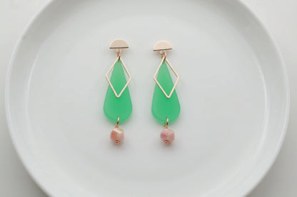 Green Mila teardrop statement earrings arranged on a white plate