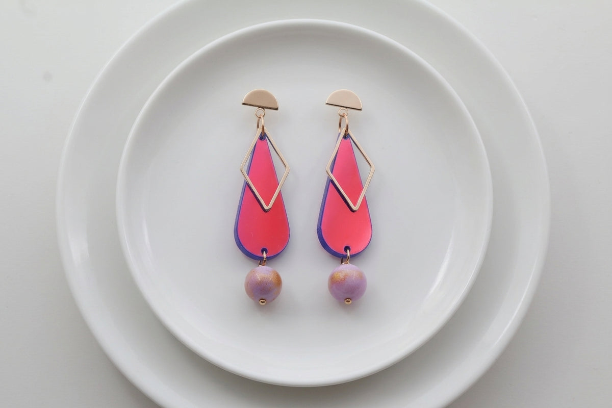 HB Mila teardrop statement earrings arranged on a white plate